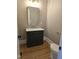 Stylish half bathroom boasts a dark green vanity with stone countertops and gold fixtures at 5480 Thom Rd, Mebane, NC 27302