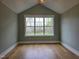 Well lit room with vaulted ceilings, hardwood floors, and a large window at 5480 Thom Rd, Mebane, NC 27302
