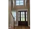 Elegant entryway featuring a wooden door, hardwood floors, and a staircase at 5480 Thom Rd, Mebane, NC 27302