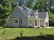 Charming two-story home with a covered front porch, lush green lawn, and attached two-car garage at 5480 Thom Rd, Mebane, NC 27302