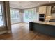 This bright kitchen features hardwood floors, white cabinetry, a green island, and stainless steel appliances at 5480 Thom Rd, Mebane, NC 27302