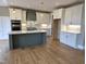 Modern kitchen featuring custom cabinets, center island, quartz countertops, stainless appliances, and hardwood floors at 5480 Thom Rd, Mebane, NC 27302
