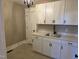 Convenient laundry room with white cabinetry, a stainless steel sink, and matching fixtures at 5480 Thom Rd, Mebane, NC 27302