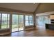 Open-concept living room with hardwood floors, views of deck, and adjacent kitchen and dining area at 5480 Thom Rd, Mebane, NC 27302