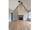 Open-concept living room featuring a fireplace, hardwood floors, and a high ceiling at 5480 Thom Rd, Mebane, NC 27302