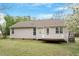 Back exterior of home with a door to the raised, wooden deck and a level, grassy yard at 5604 Stardust Dr, Durham, NC 27712