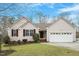 Charming single-story home with neutral siding, red shutters, a well-manicured lawn, and an attached garage at 5604 Stardust Dr, Durham, NC 27712