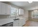 Kitchen features white cabinets and a stainless steel sink under a window at 5604 Stardust Dr, Durham, NC 27712