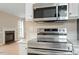 Modern kitchen showcasing stainless steel appliances with a fireplace and a window view at 5604 Stardust Dr, Durham, NC 27712