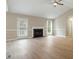 Inviting living room features a cozy fireplace, a ceiling fan, and abundant natural light with access to the backyard at 5604 Stardust Dr, Durham, NC 27712