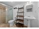 Bathroom featuring a modern toilet, pedestal sink, tile floors and shower with glass doors at 5864 Whitney Rd, Graham, NC 27253