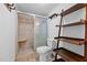 Bathroom showcasing tile floors, a shower with glass doors, and a decorative shelving unit at 5864 Whitney Rd, Graham, NC 27253