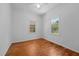 Bedroom showcasing hardwood floors, white walls, and natural light from windows at 5864 Whitney Rd, Graham, NC 27253