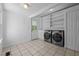 Laundry room with modern appliances, storage shelves, and exterior access at 5864 Whitney Rd, Graham, NC 27253