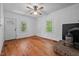 Cozy living room with hardwood floors, a ceiling fan and rustic brick fireplace at 5864 Whitney Rd, Graham, NC 27253
