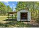 Outdoor storage shed with open door and covered area for storing equipment and lawn care tools at 5864 Whitney Rd, Graham, NC 27253