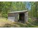 Small, open shed on a wooded lot, perfect for storage or hobby use at 5864 Whitney Rd, Graham, NC 27253