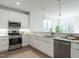 Well-lit kitchen with stainless steel microwave and stove, white cabinets, and a subway tile backsplash at 620 Walnut Heights Dr # 101, Raleigh, NC 27610