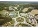 Expansive aerial view of the community, featuring lush greenery, a golf course, roundabout, and recreational facilities at 7 Brandon Pines Ct, Pittsboro, NC 27312