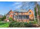 Spacious backyard with red brick exterior, screened in porch, and mature trees at 702 Orange Ct, Elon, NC 27244
