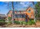 Spacious backyard with red brick exterior, screened in porch, swing set, and mature trees at 702 Orange Ct, Elon, NC 27244