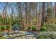 Beautiful backyard featuring a swing surrounded by lush greenery and a stone patio at 702 Orange Ct, Elon, NC 27244