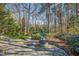 Scenic backyard with a stone patio, fountain, landscaping, and a swing, perfect for relaxation at 702 Orange Ct, Elon, NC 27244