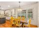 Dining area featuring wood floors, a chandelier, and natural light from the many windows at 702 Orange Ct, Elon, NC 27244