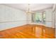 Formal dining room with hardwood floors, decorative wallpaper, and bay window at 702 Orange Ct, Elon, NC 27244