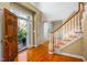 Inviting foyer with hardwood floors, staircase, and natural light streaming through the front door at 702 Orange Ct, Elon, NC 27244