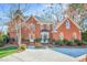 Charming two-story red brick home with landscaped front yard and mature trees at 702 Orange Ct, Elon, NC 27244