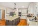 Classic kitchen includes granite counters, stainless appliances, white cabinetry, and center island with dark wood base at 702 Orange Ct, Elon, NC 27244