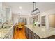 Bright kitchen features wood floors, an island with barstool seating, and an attached eat-in dining area at 702 Orange Ct, Elon, NC 27244