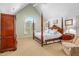 This luxurious bedroom features a four-poster bed, vaulted ceilings, and an arched window at 702 Orange Ct, Elon, NC 27244
