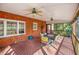 Charming screened porch with brick flooring, a ceiling fan, and outdoor dining set for entertaining guests at 702 Orange Ct, Elon, NC 27244
