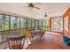 Inviting screened-in porch with brick flooring, ceiling fans, and comfortable outdoor dining area at 702 Orange Ct, Elon, NC 27244