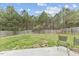 Spacious backyard with a well-maintained lawn, tall trees, and a wooden fence at 707 Obsidian Way, Durham, NC 27703