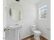 Bathroom featuring a pedestal sink, toilet, and window with natural light at 707 Obsidian Way, Durham, NC 27703