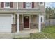 Inviting front entrance with stone accents, a covered porch, and a single-car garage at 707 Obsidian Way, Durham, NC 27703