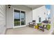 Covered patio with sliding glass door access, featuring outdoor seating overlooking the green backyard at 712 Holstein Dairy Way, Wake Forest, NC 27587