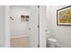 En-suite bathroom with toilet, neutral walls, and view into walk-in closet with wire shelving at 712 Holstein Dairy Way, Wake Forest, NC 27587