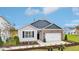 Charming one-story home with brick and gray siding, an attached two-car garage and a well-manicured lawn at 712 Holstein Dairy Way, Wake Forest, NC 27587