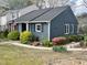 Home exterior with blue siding, white trim, an American flag, and lush landscaping at 7429 Ashbury Ct, Raleigh, NC 27615