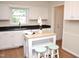 Modern kitchen featuring white cabinets, black countertops, a wooden island, and stainless steel sink at 7429 Ashbury Ct, Raleigh, NC 27615