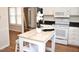 Kitchen featuring white cabinets, stainless steel appliances, and a bright wooden island at 7429 Ashbury Ct, Raleigh, NC 27615