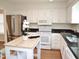 Bright kitchen featuring modern appliances, a wooden island, and white cabinetry at 7429 Ashbury Ct, Raleigh, NC 27615