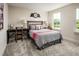 Bedroom with a striped bedspread and black metal bedframe, desk and lamps, and a beautiful view of a country field at 801 Walker Ridge Way, Willow Springs, NC 27592