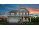 Charming two-story home featuring a covered porch and two-car garage at sunset at 801 Walker Ridge Way, Willow Springs, NC 27592