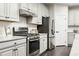 The kitchen boasts stainless steel appliances, white cabinets, and subway tile backsplash at 801 Walker Ridge Way, Willow Springs, NC 27592
