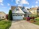 Charming two-story home with manicured lawn, attached two-car garage, and beautiful landscaping at 814 Ember Dr, Durham, NC 27703